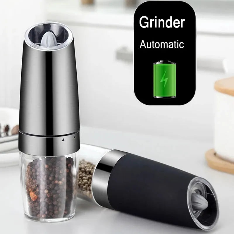 Electric gravity pepper grinder with clear acrylic body and blue LED light on a kitchen countertop