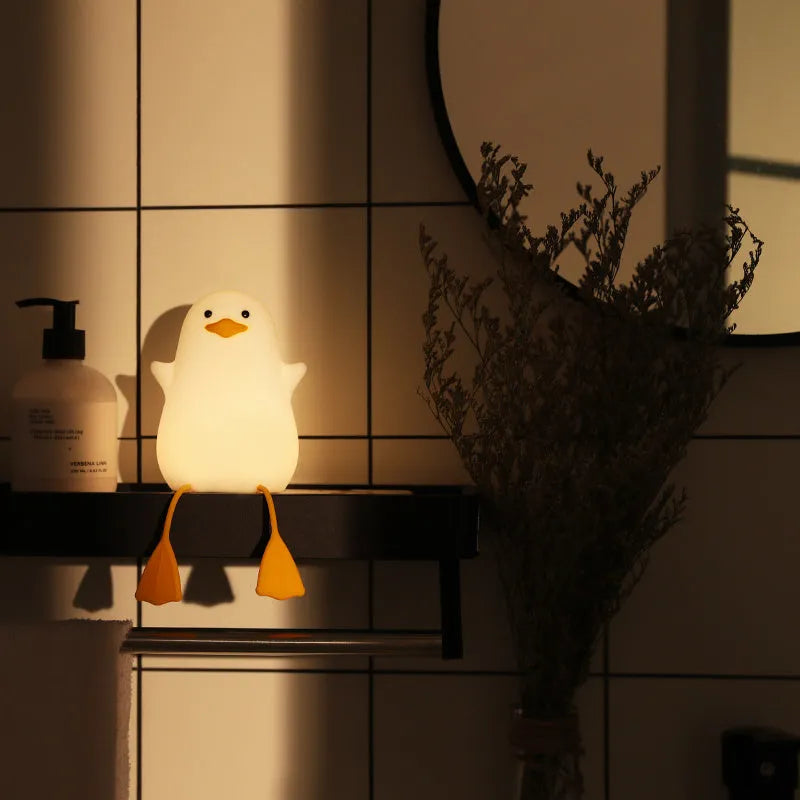Little Gull rechargeable silicone night light in blue mouth on a bedside table