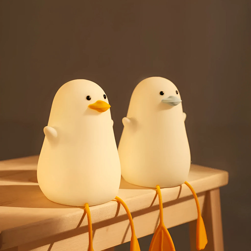 Little Gull rechargeable silicone night light in blue mouth on a bedside table