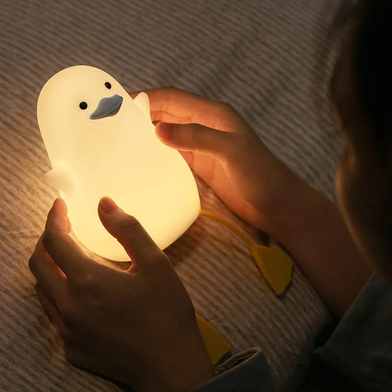 Little Gull rechargeable silicone night light in blue mouth on a bedside table
