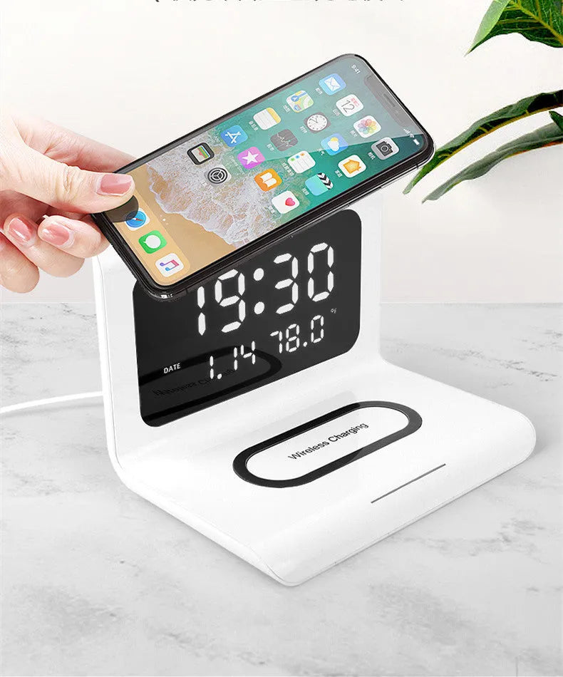 White and black wireless charging alarm clock showing time, date, temperature, and humidity on its display.