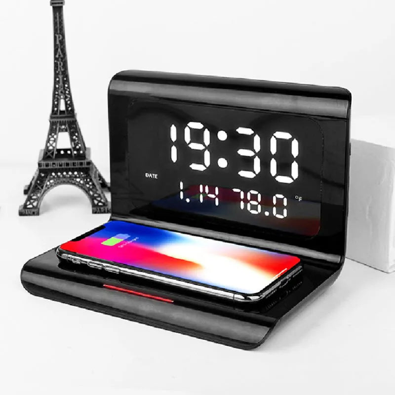 White and black wireless charging alarm clock showing time, date, temperature, and humidity on its display.