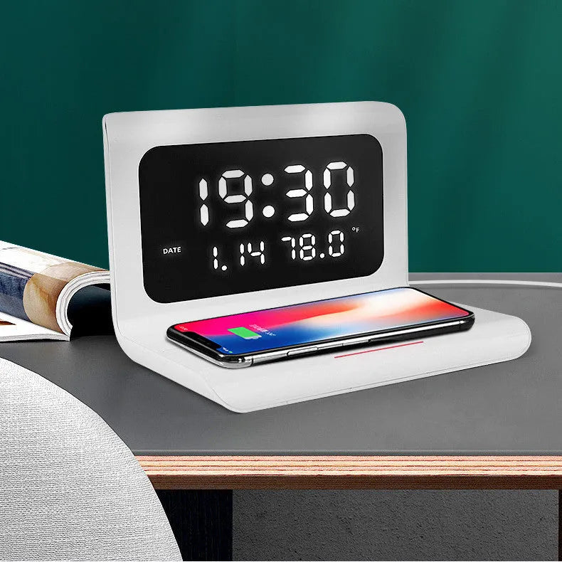 White and black wireless charging alarm clock showing time, date, temperature, and humidity on its display.