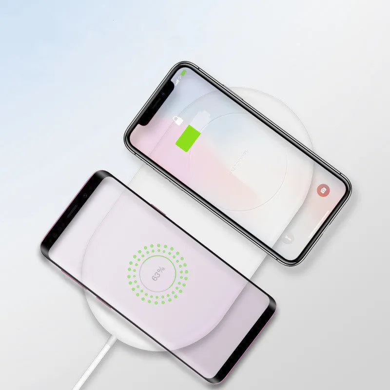 White dual wireless charger charging two mobile phones side by side