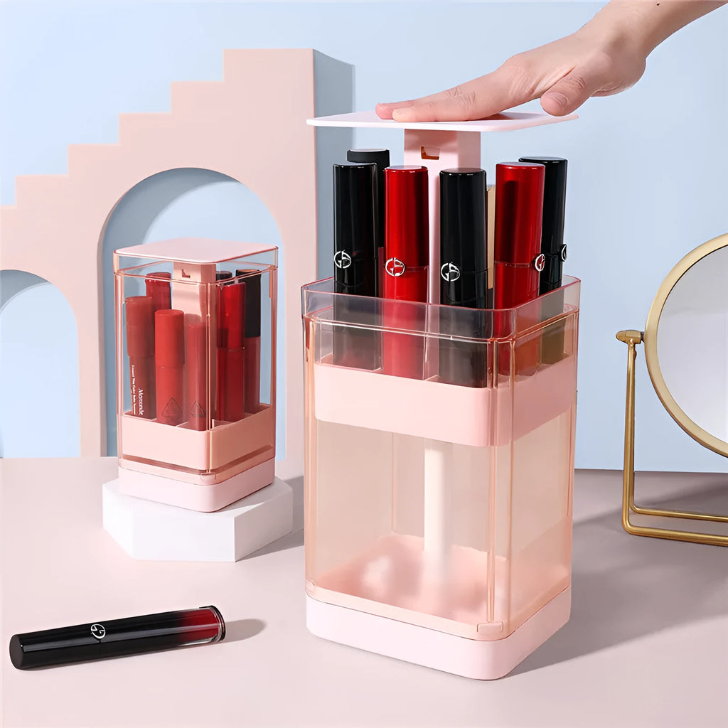 Clear pink press-lid lipstick storage box showing 12 individual slots for makeup organisation on a desk.