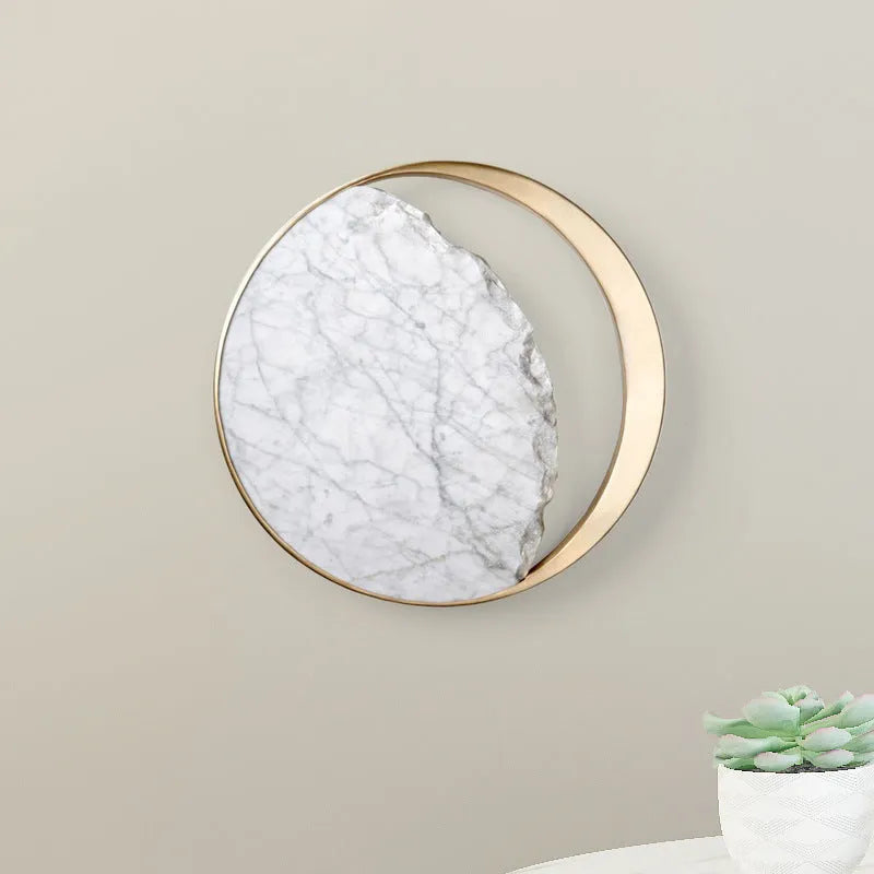 Round marble and copper LED wall lamp with eclipse design, 25 cm diameter, on a textured wall