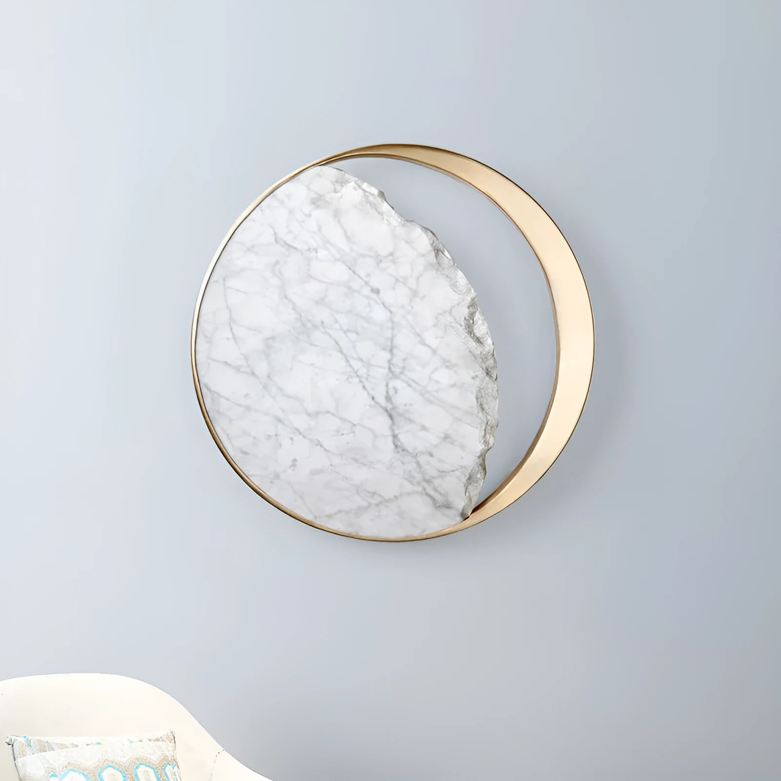 Round marble and copper LED wall lamp with eclipse design, 25 cm diameter, on a textured wall