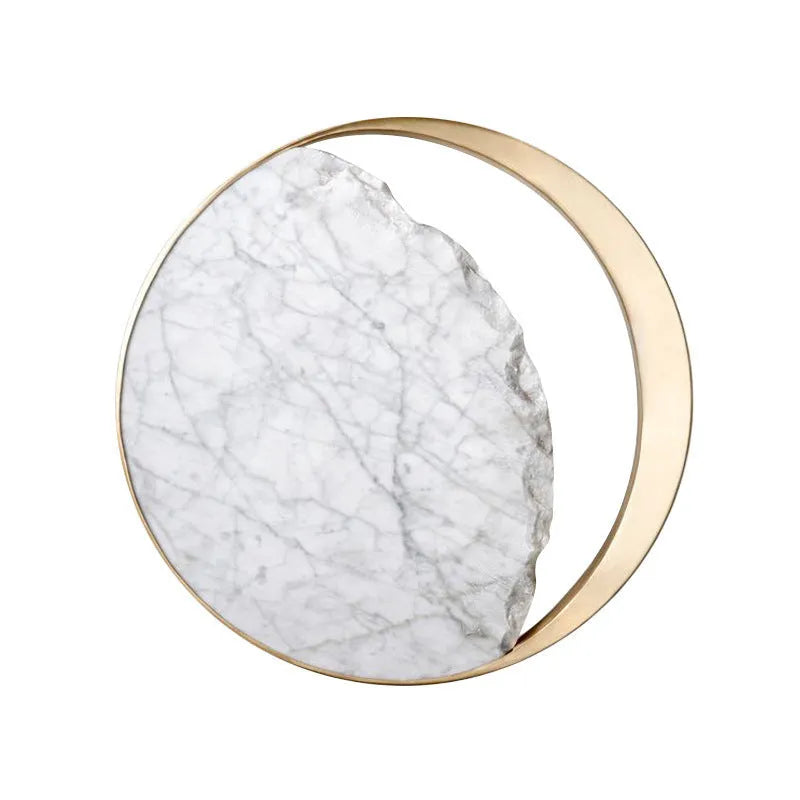 Round marble and copper LED wall lamp with eclipse design, 25 cm diameter, on a textured wall
