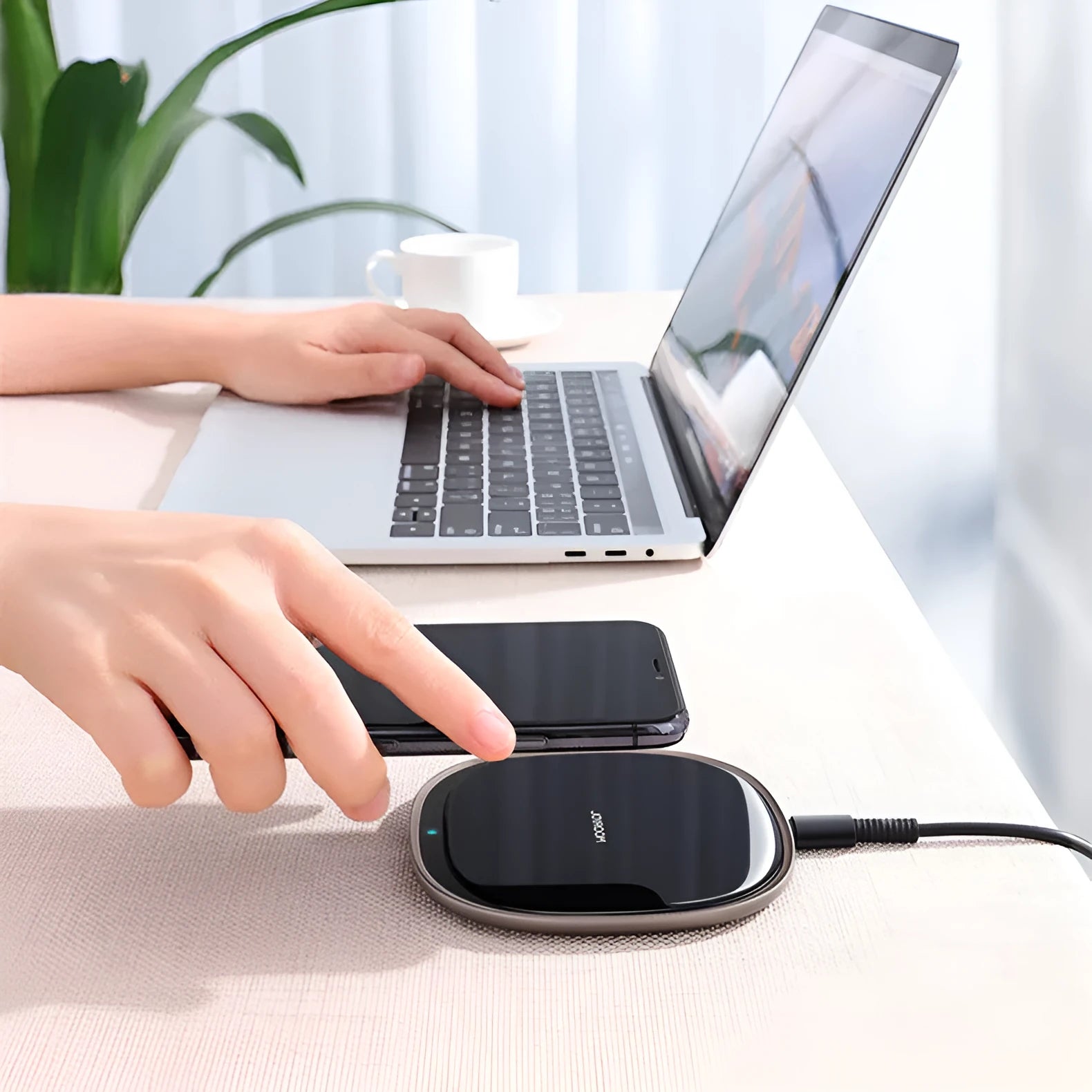 Black 15W Qi wireless charging pad with glass top and zinc alloy base on a desk.
