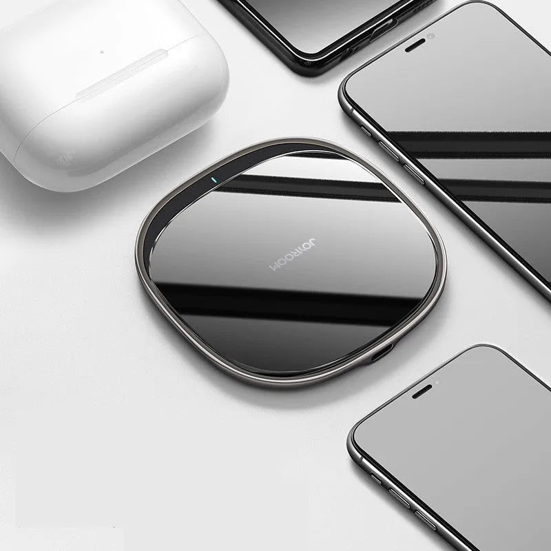 Black 15W Qi wireless charging pad with glass top and zinc alloy base on a desk.