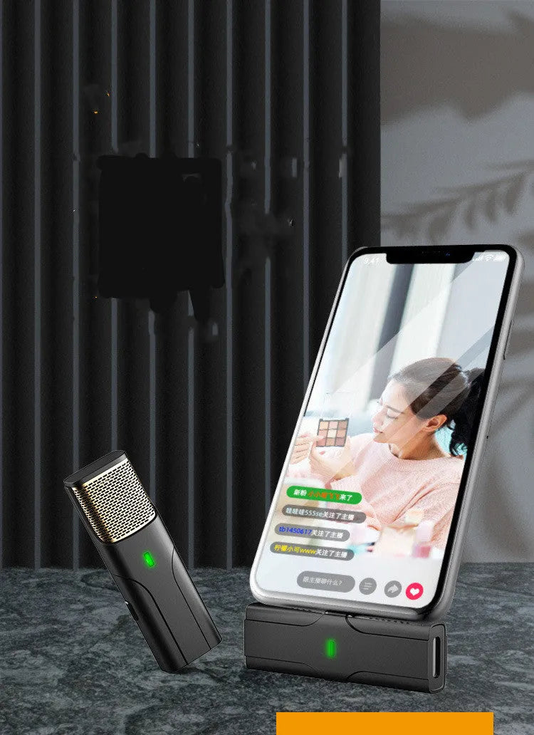 Black wireless lavalier lapel microphone with clip and Type-C charging cable on a table.