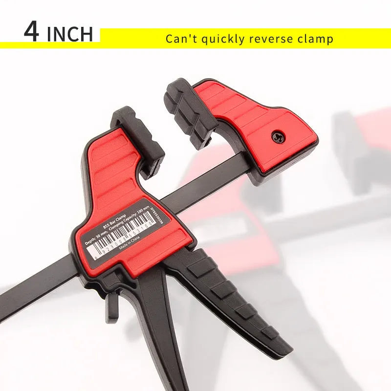 Black plastic woodworking clamp with quick-adjust key and soft rubber protective grip.