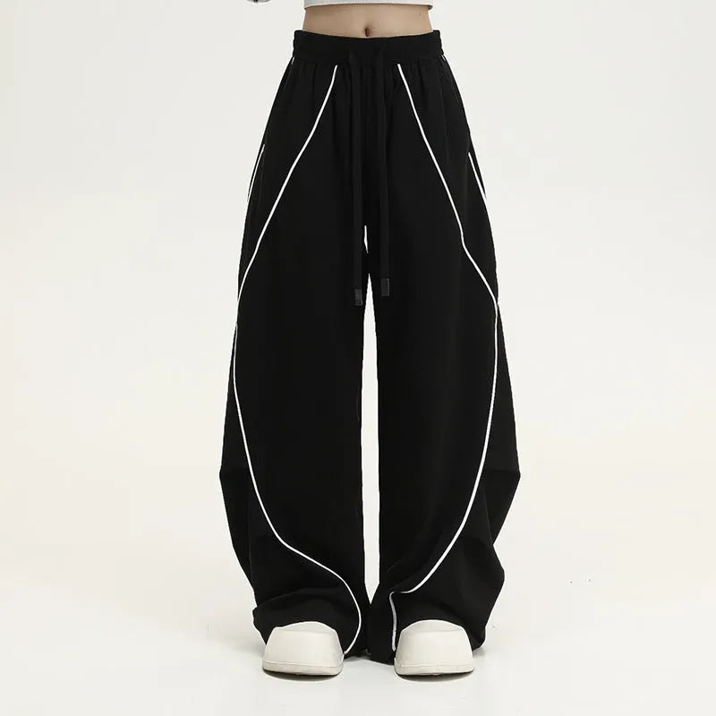 Black pleated wide-leg hip hop trousers with a striped pattern on a mid waist.