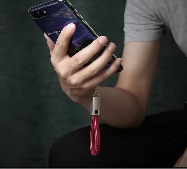 Short red leather braided USB-C to Apple Lightning charging cable on a white background