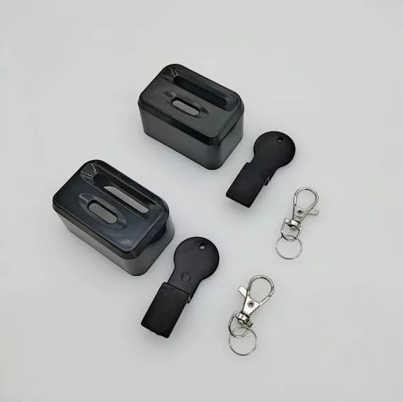 Black ABS plastic seat belt buckle protective cover shown next to vehicle seat belt