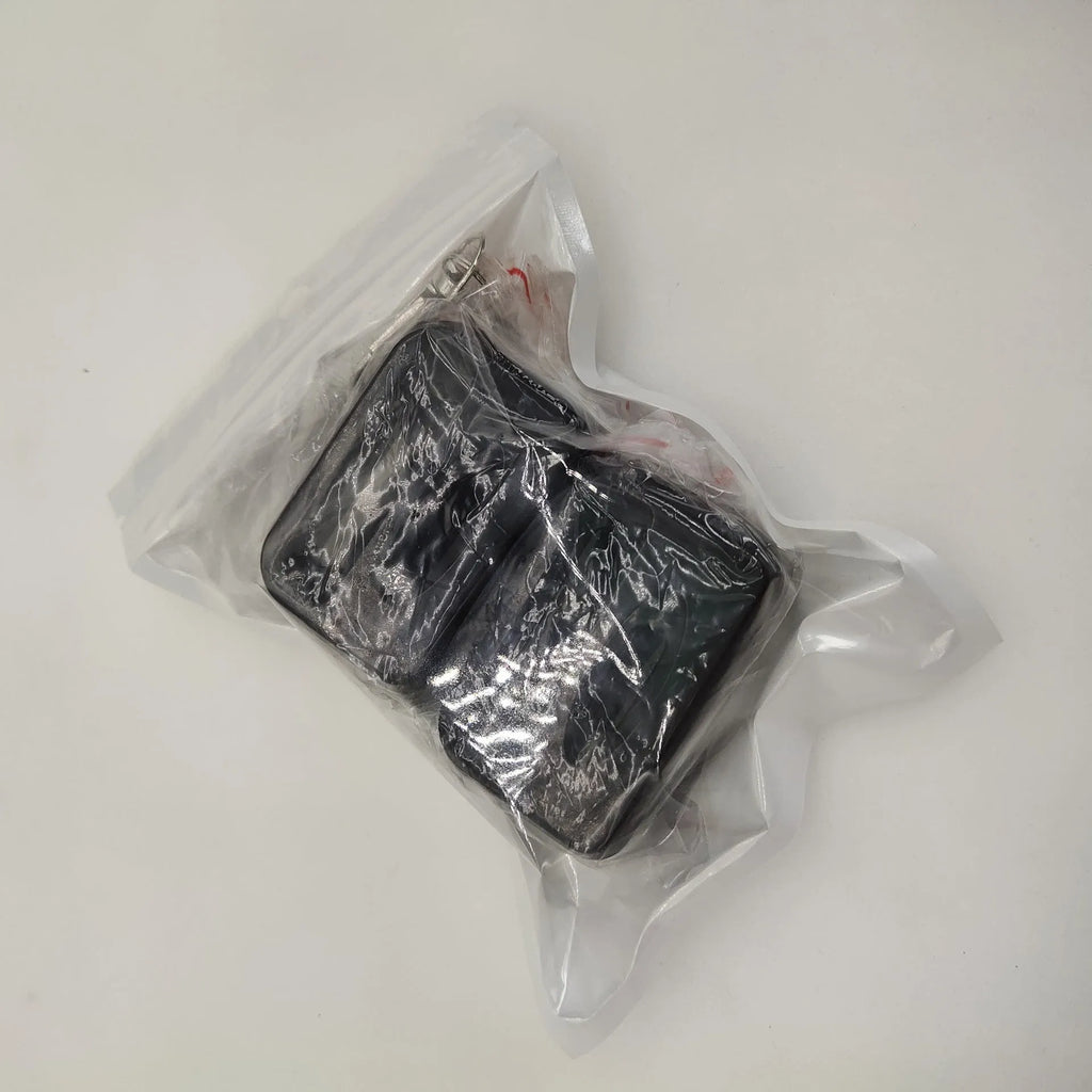 Black ABS plastic seat belt buckle protective cover shown next to vehicle seat belt