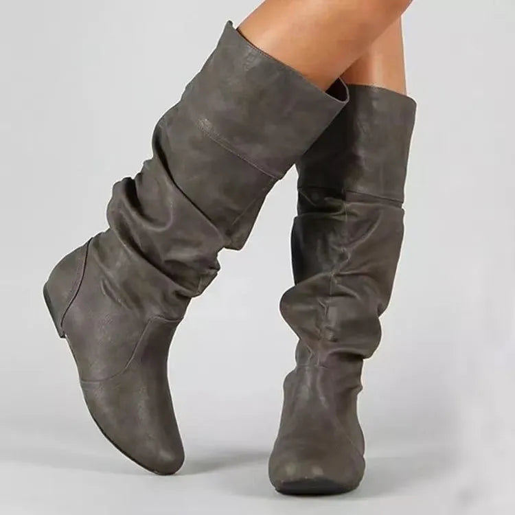 Women's flat black slip-on ankle boots with round toe and high shaft on a rubber sole.
