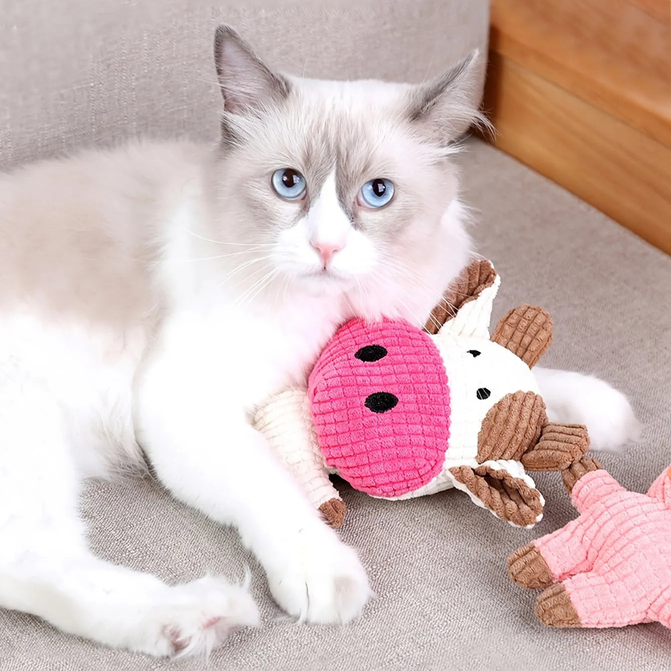 Animal-shaped plush dog chew toy with squeaker in assorted colours including blue, brown, and cow print.