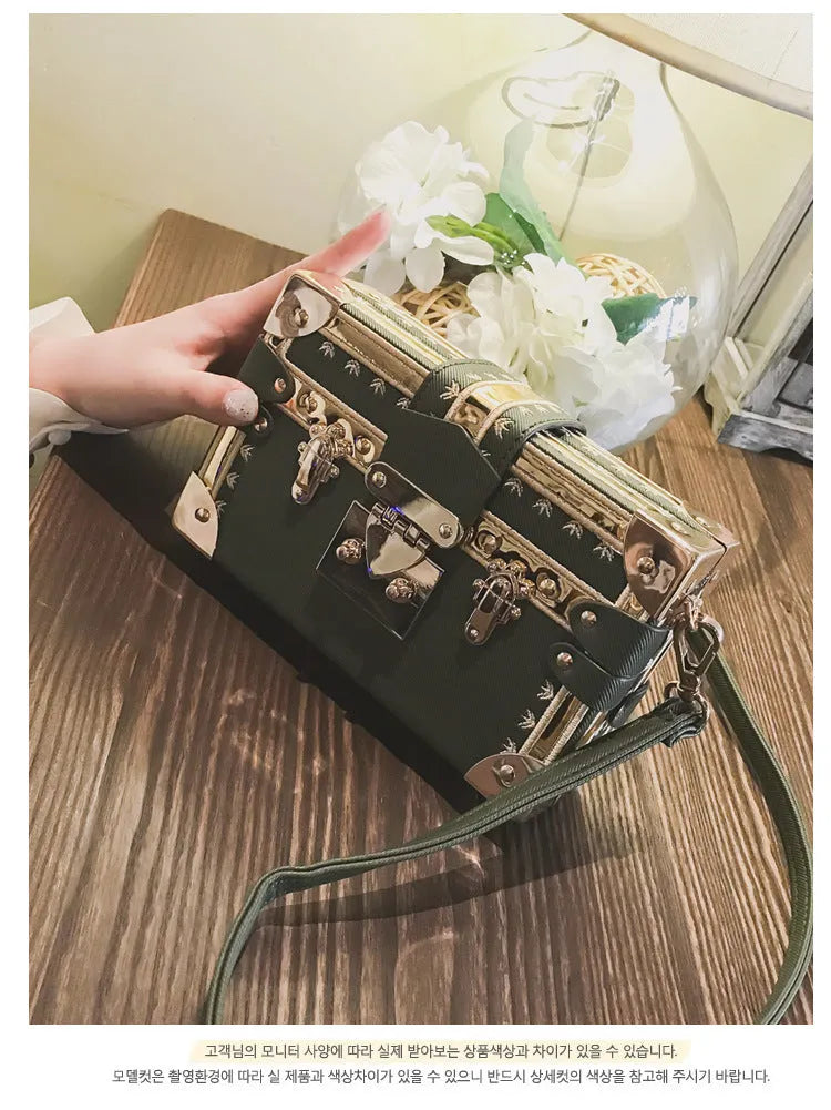 Black or green women's hard-shell flap-over shoulder bag with single adjustable strap
