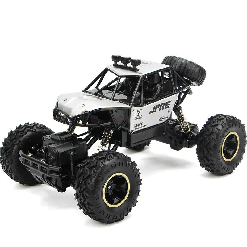 Large black and silver 4WD remote control off-road climbing cars with wireless controller on a rocky surface.