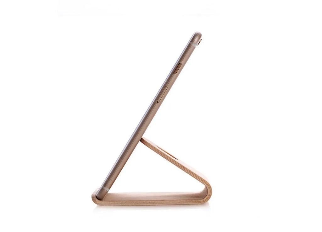 Wooden desk stand holding an iPhone, shown in walnut and white maple wood finishes.