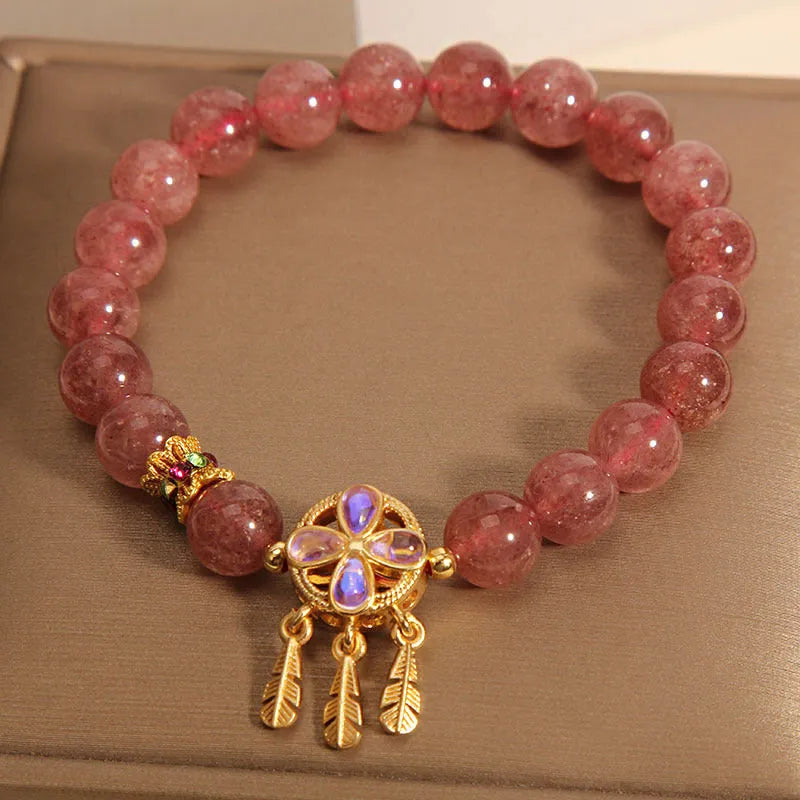 Women's Strawberry Quartz crystal bracelet with a four leaf clover dream catcher ball pendant.
