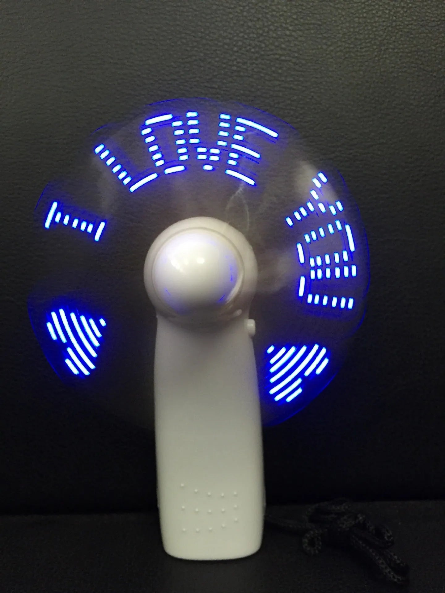 White handheld fan with LED lights displaying I Love You pattern in blue and red colours