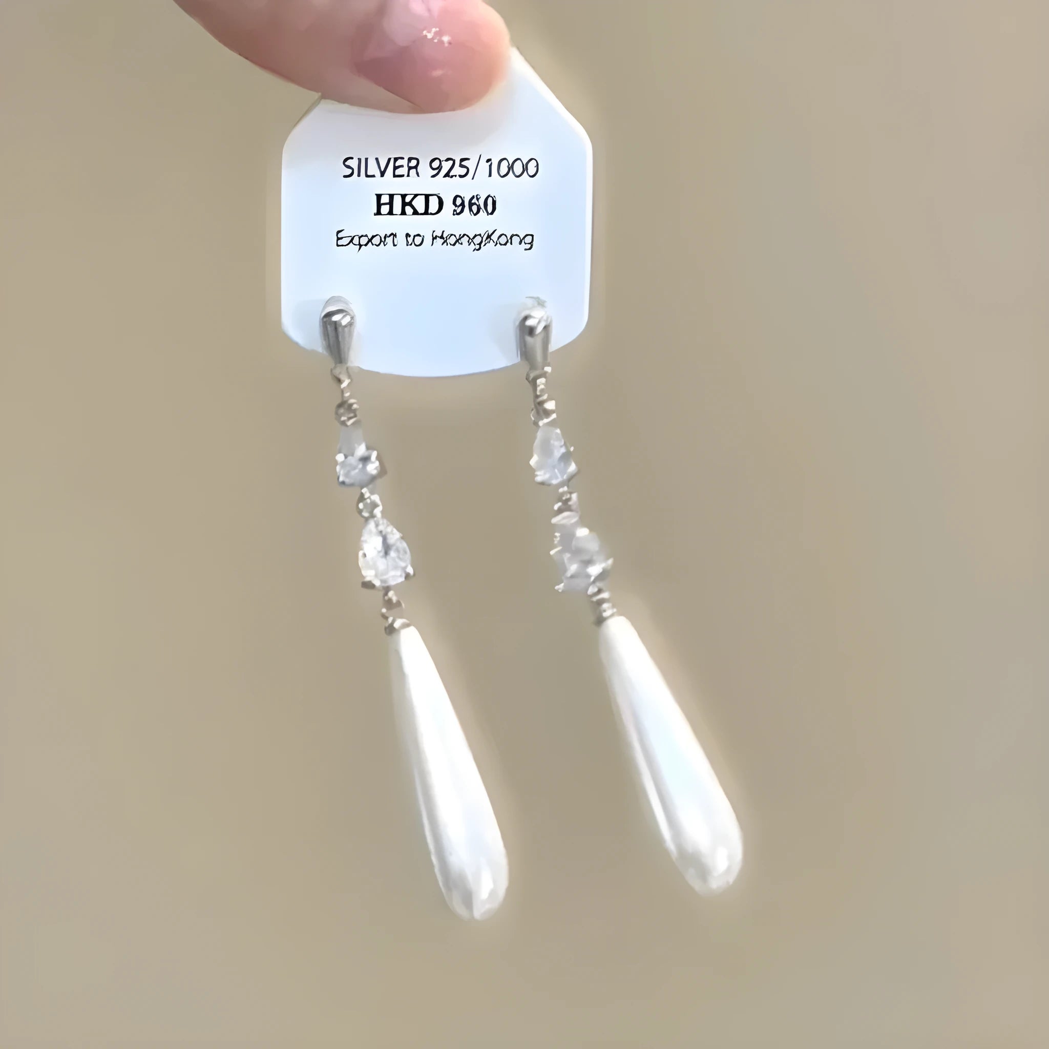 Silver geometric heart-shaped clip-on earrings with rhinestones and a dangling star tassel charm.