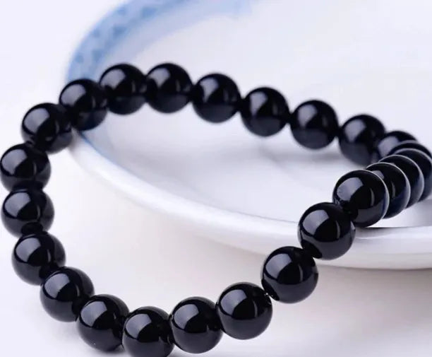 Geometric black agate beaded bracelet with 8mm stones on a black elastic cord.