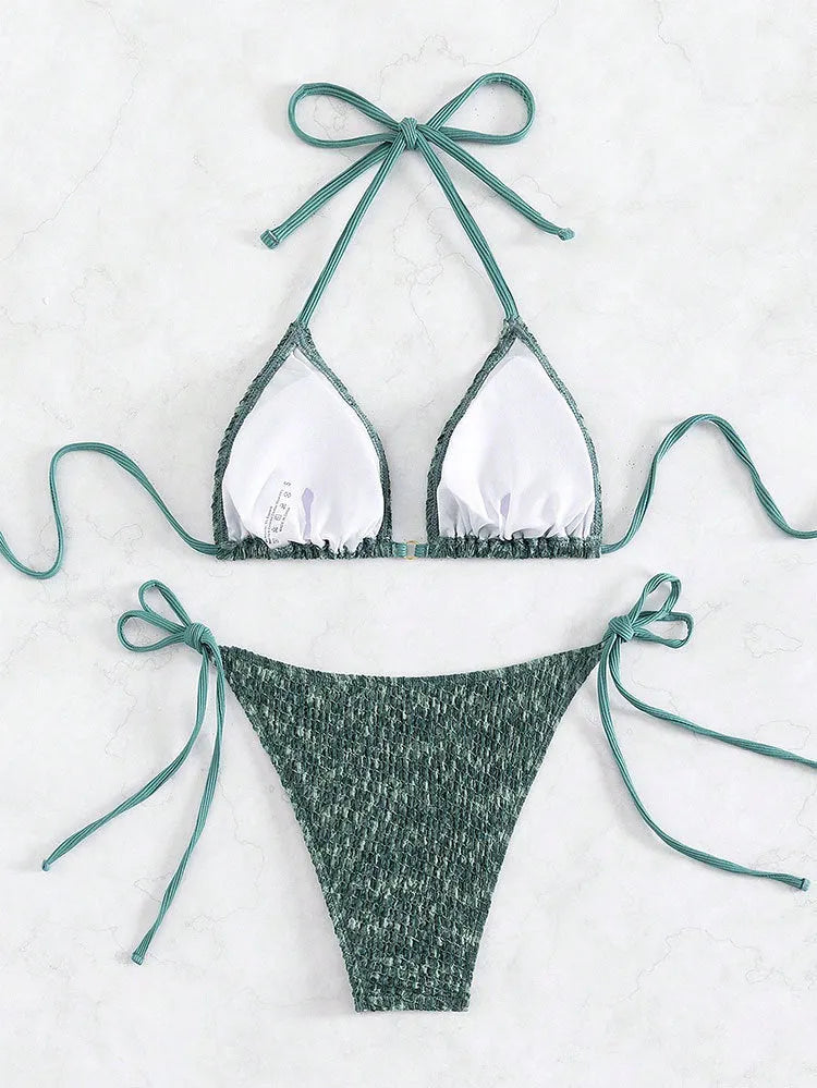 Green women's backless halter bikini set with shorts on a mannequin.