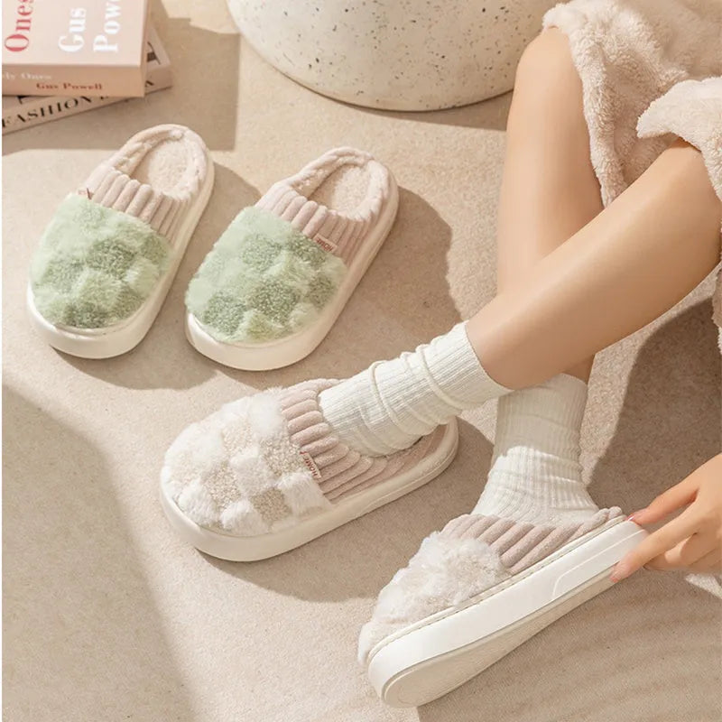 Women's plaid patterned plush slippers with non-slip sole in multiple colours on a wooden floor.