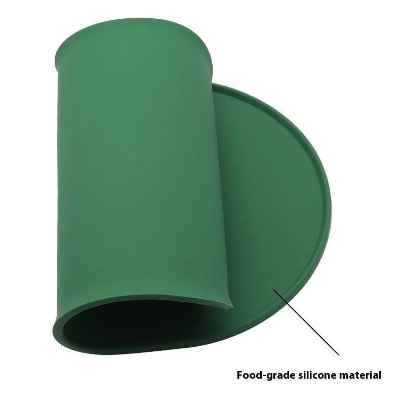 Green silicone cat feeding placemat with a food bowl on it, showing its waterproof, wipe-clean surface.