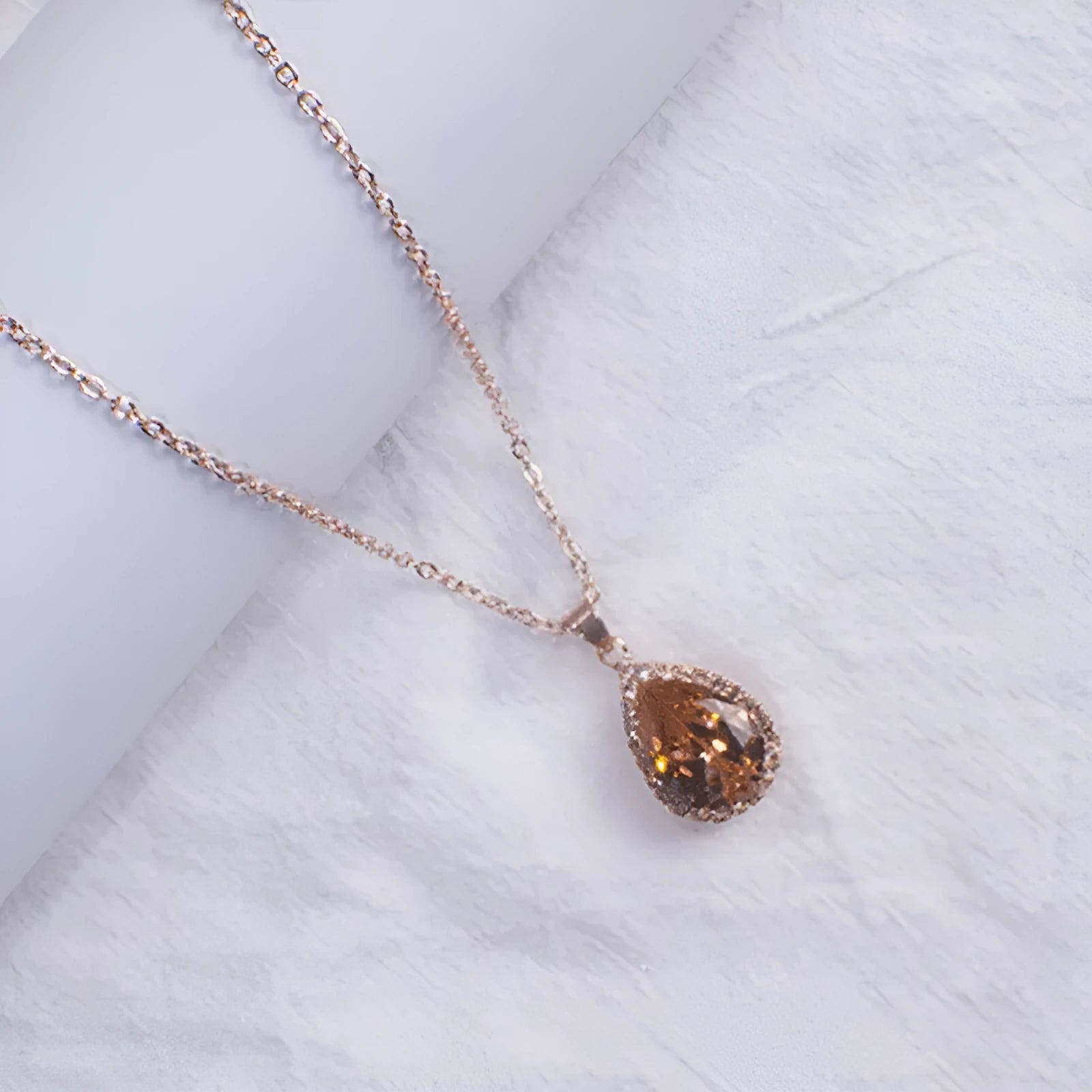 Women's pink rhinestone drop necklace with rose gold electroplated finish and geometric design