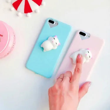 A soft pink silicone iPhone case featuring a raised 3D cartoon cat design on the back.