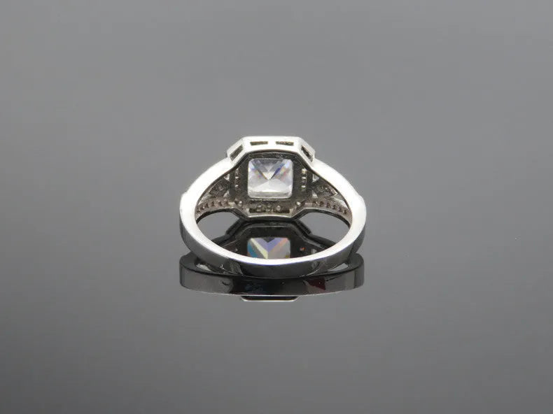 Women's geometric zircon ring with platinum finish on a copper band, showing hollow construction and quadrilateral design.