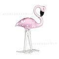 White crystal flamingo decorative ornaments with pink dots on a table