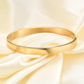 Polished stainless steel snap bracelet with oval links on plain background