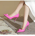 Women's pink patent leather stiletto heels with pointed toe, buckle ankle strap, and stiletto heel