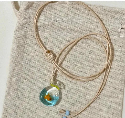 Women's necklace with coloured glaze joker pendant on a beige cotton and linen clavicle chain.