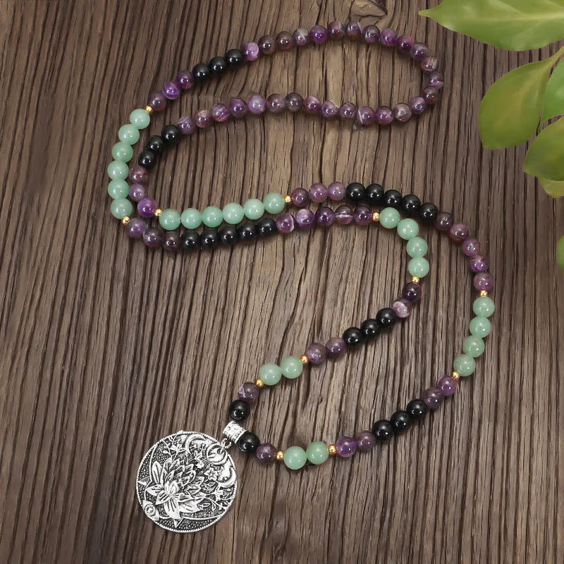 Yoga necklace with geometric lotus pendant and stone bead chain alongside a matching bracelet