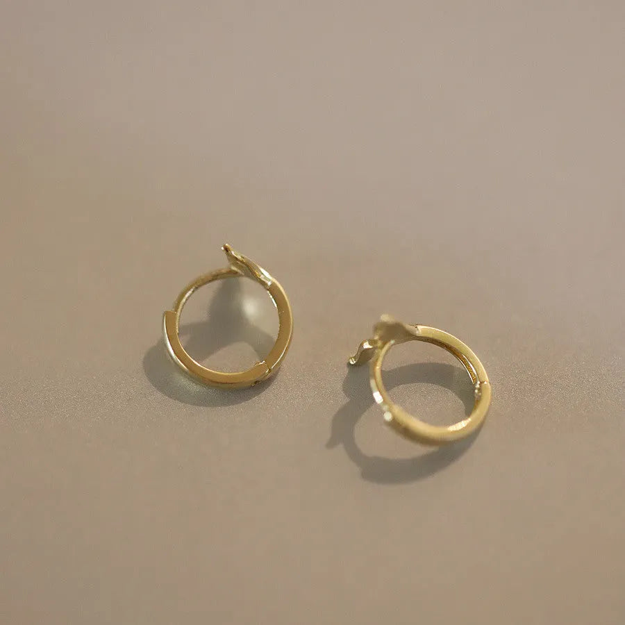 Gold plated sterling silver fishtail earrings with smooth finish and 8-10mm diameter.