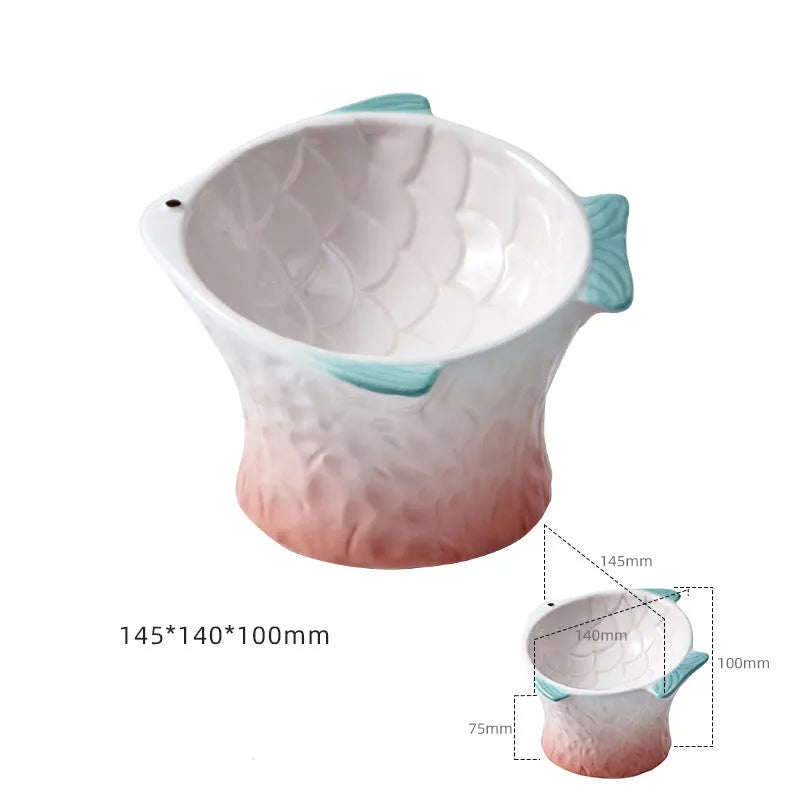 Set of four coloured fish-shaped ceramic cat bowls with a tilted, elevated design on a table.