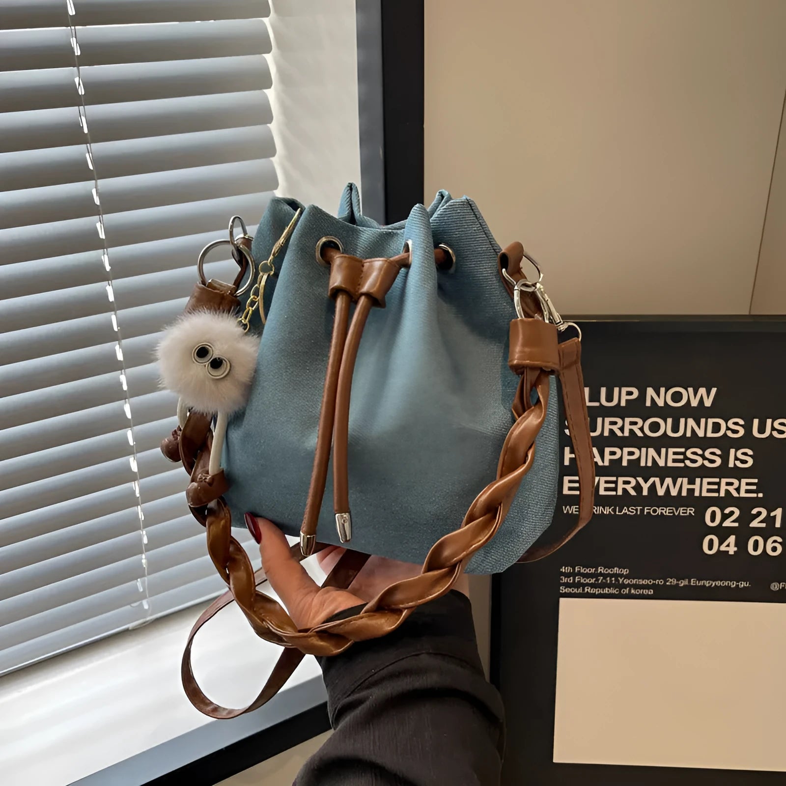 Blue synthetic leather cross body bucket bag with sandwich pocket and sling strap