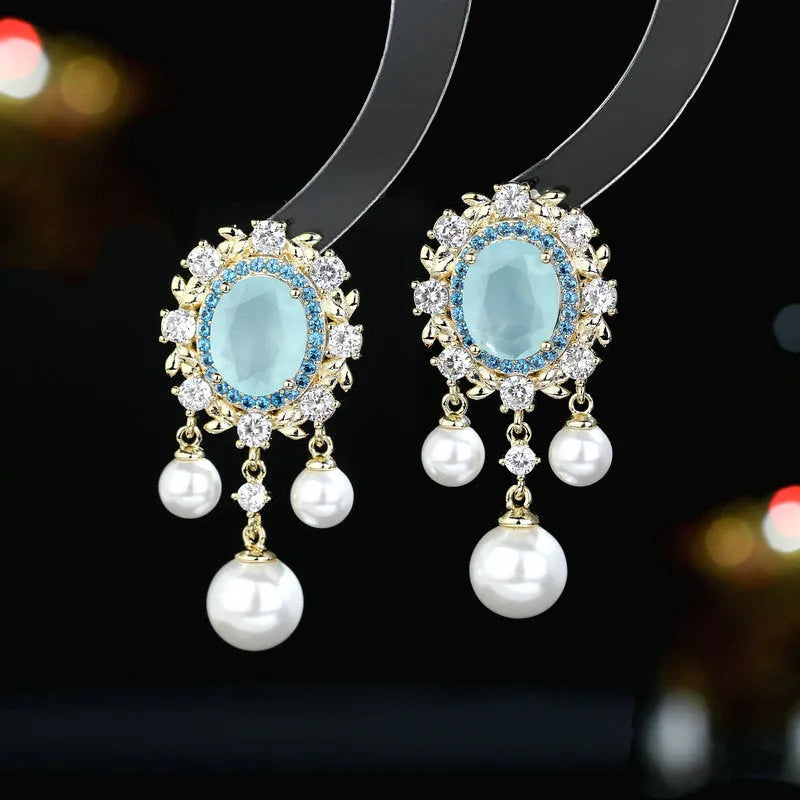Oval-shaped copper earrings with inlaid zircon and a dangling pearl tassel in light purple.