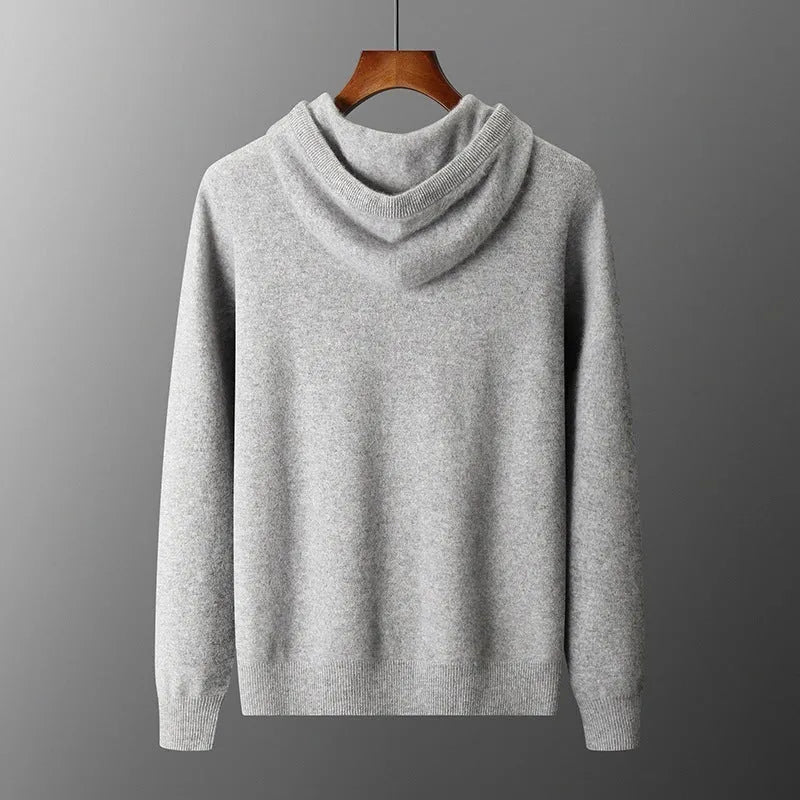 Man wearing a light grey hooded cashmere sweatshirt and matching long pants from a winter leisure set.