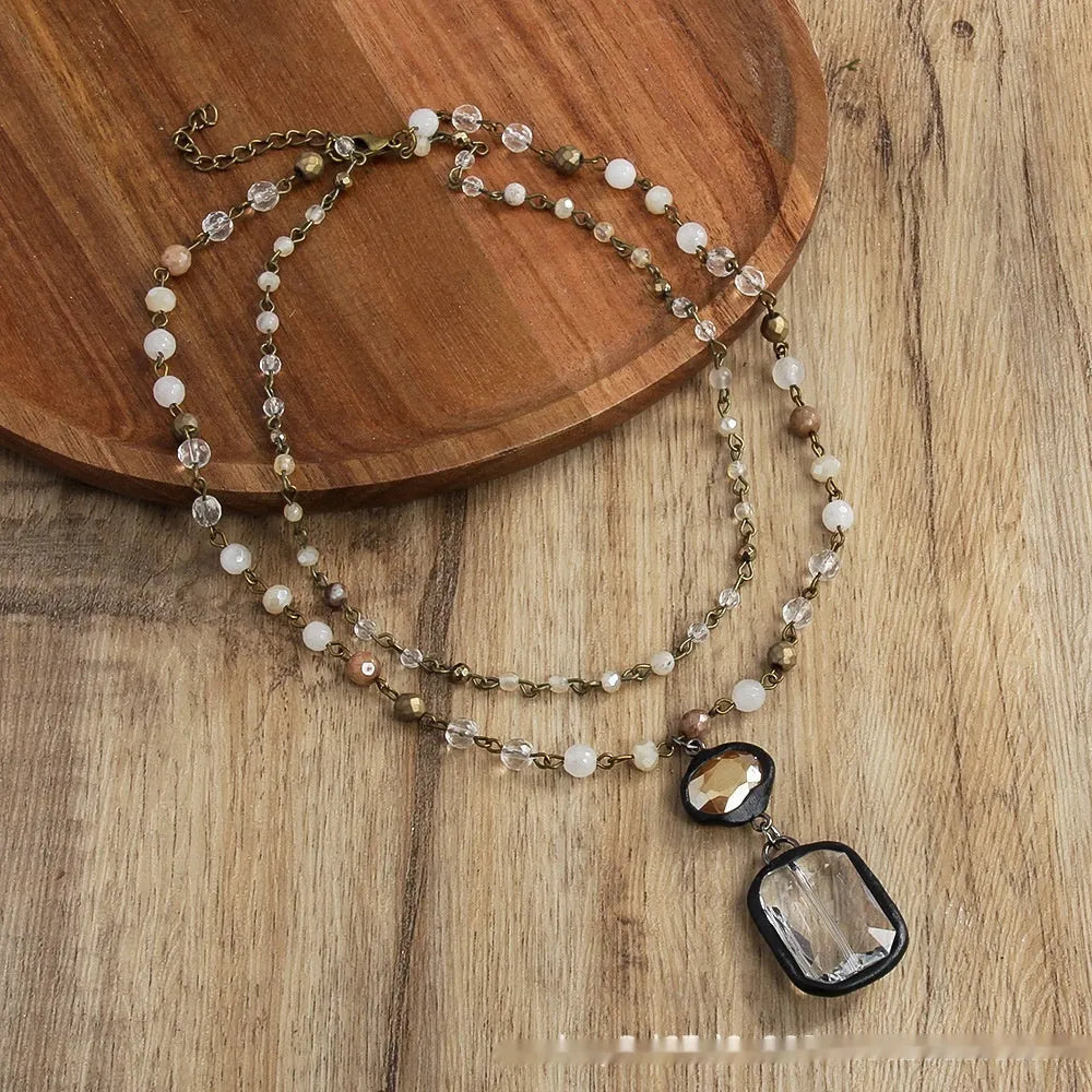 Tribal-style layered necklace with glass pendant and adjustable chain in beige or blue.