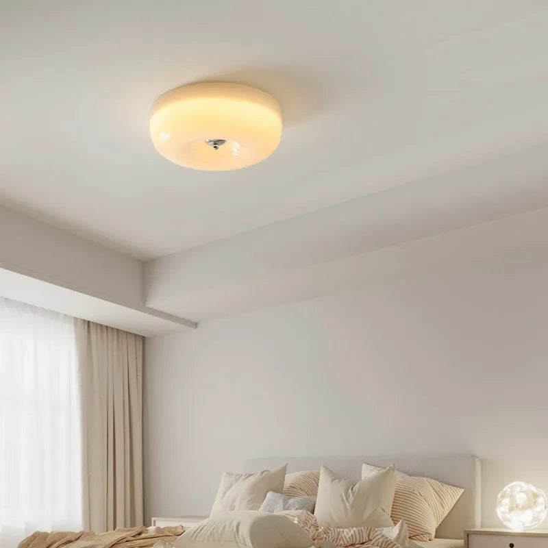 American-style antique finish ceiling lamp with cream coloured shade in bedroom setting