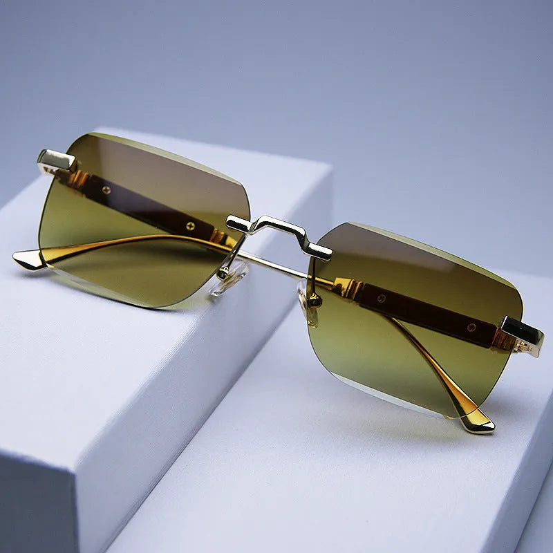 Frameless edge-cut sunglasses with gold frame, wood grain legs, and gradient grey lenses on a neutral background