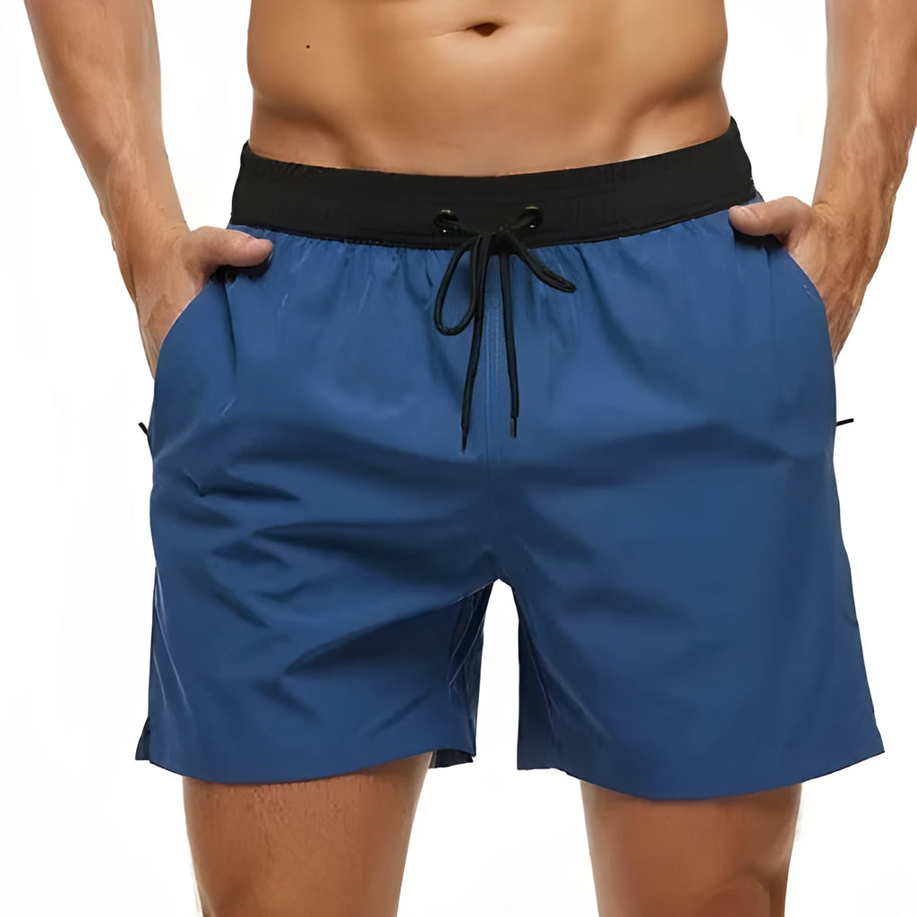 Men's blue athletic shorts with stitching waist detail, drawstring, zipper, and side pockets.