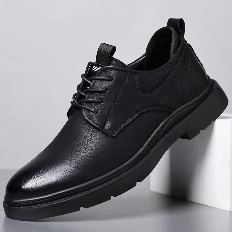 Men's black and brown leather casual sneakers with visible sewing line detail on the cowhide upper.